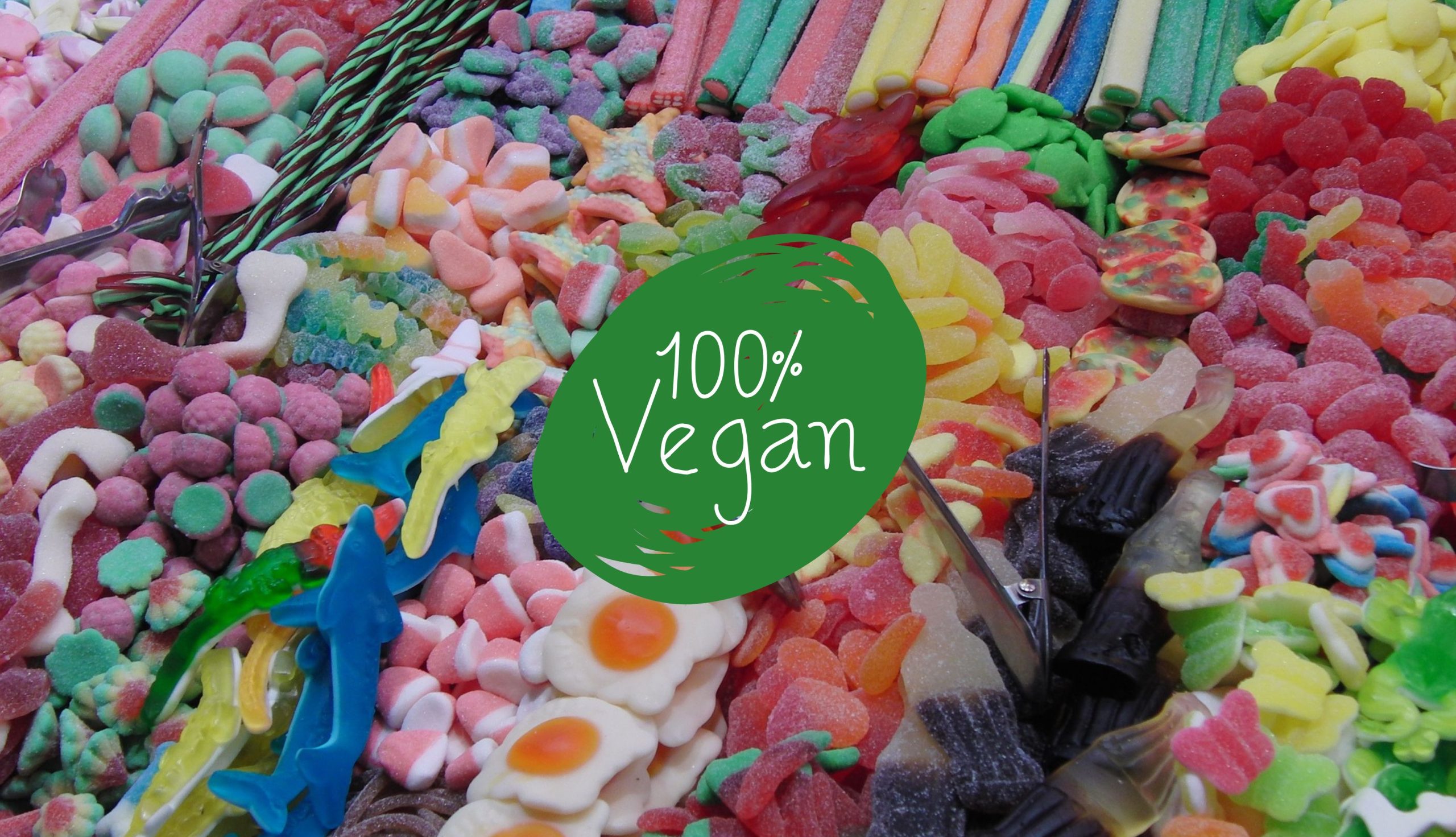 Caramelle gommose vegane di varie forme e colori disposte in file su una bancarella di mercato