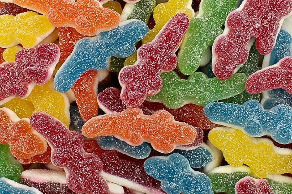 Primo piano di colorate caramelle gommose a forma di coccodrillo Haribo Coccodrì , ricoperte di cristalli di zucchero nei toni del rosso, blu, verde, giallo e arancione.