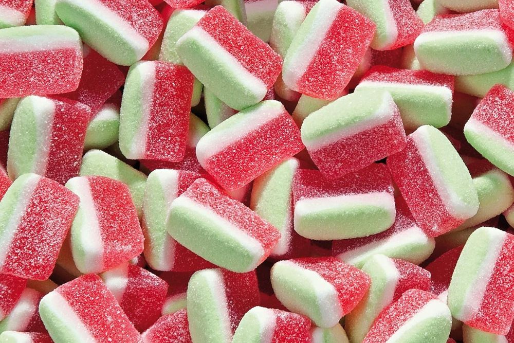 Primo piano di caramelle gommose Haribo Anguria bianche, rosse e verdi ricoperte di cristalli di zucchero.