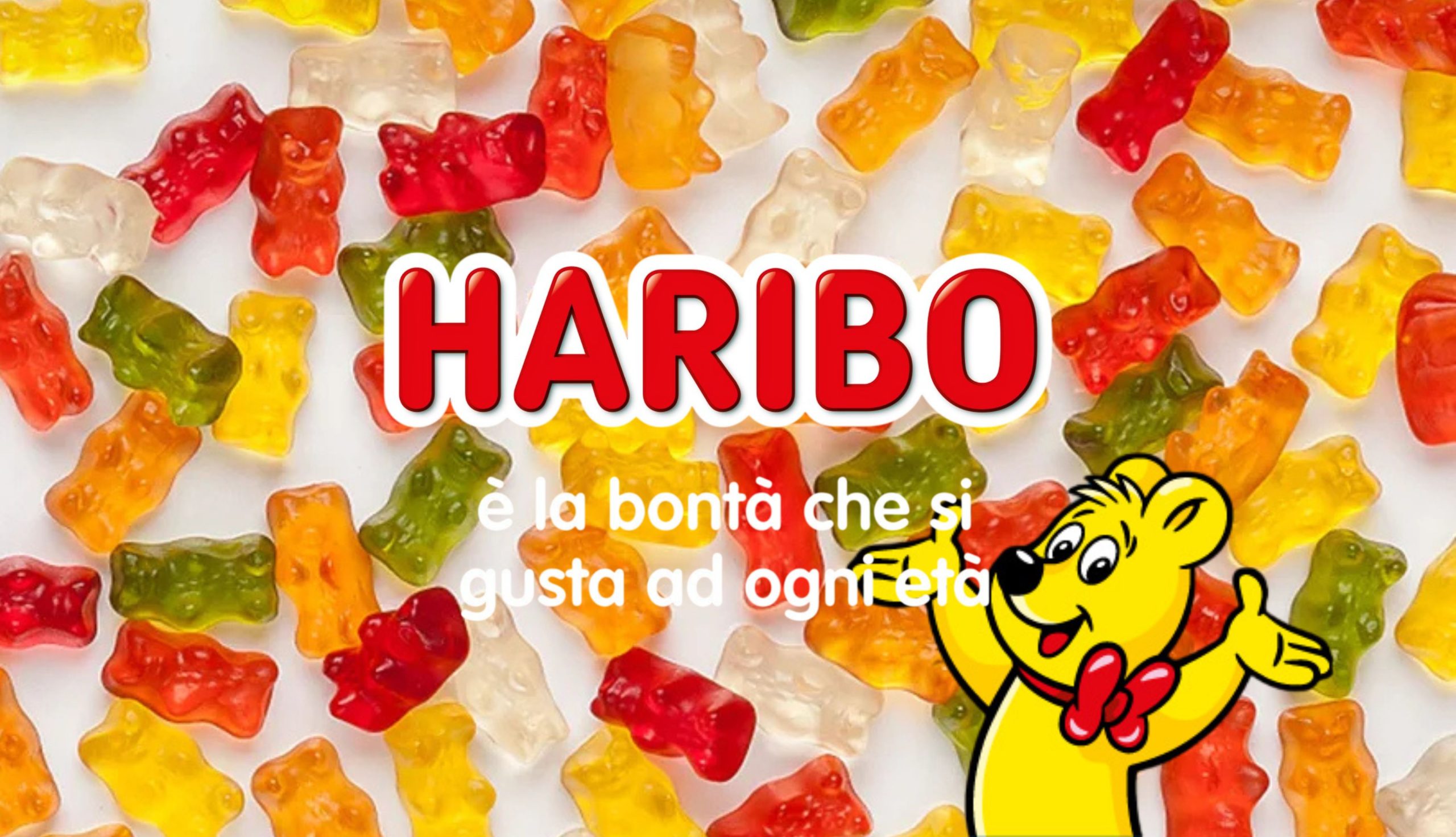 Orsetti gommosi colorati Haribo sparsi su uno sfondo bianco con il logo HARIBO, una simpatica mascotte orsetto giallo con papillon rosso e lo slogan 