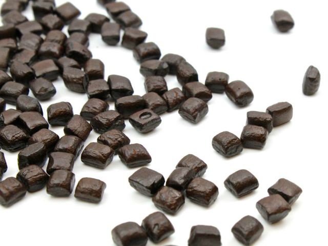 Quadratini di Liquirizia pura grezza di Shiraz sparse su sfondo bianco