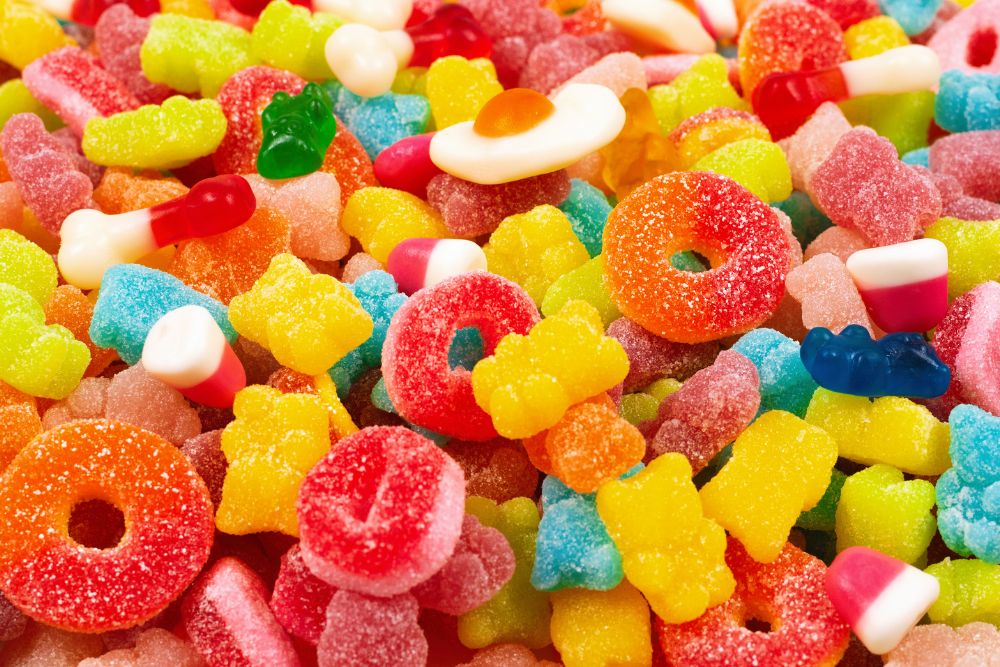 Varietà colorata di caramelle gommose zuccherate a forma di orsetti, anelli e uova fritte.