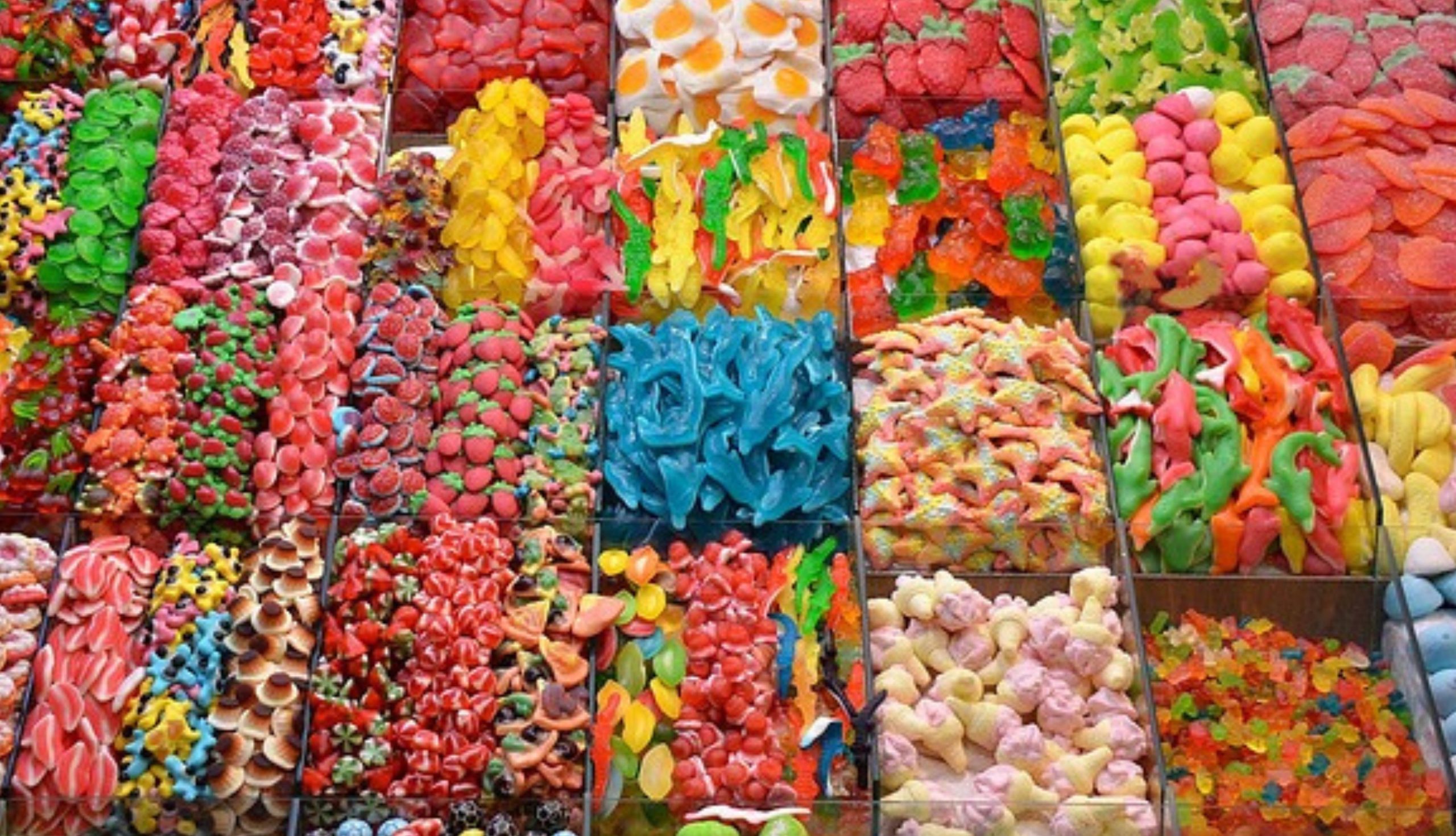 Vassoi assortiti di caramelle gommose colorate di varie forme e gusti in esposizione